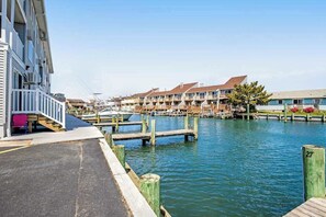 Ein Yachthafen mit vertäuten Booten, einer Holzpromenade und einem Gebäude mit Balkonen.
