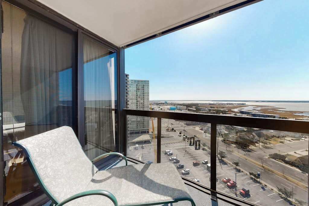 Ein Balkon mit Blick auf einen Parkplatz und Gebäude.