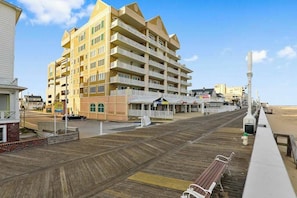 A multi-story hotel with balconies, a boardwalk, and beach access. - South Beach 703 (Ocean City)