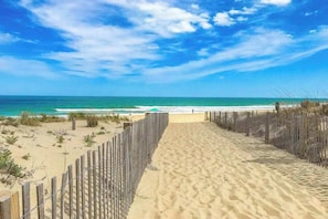 A sandy beach path leading to the ocean, bordered by wooden fences. - Swathmore 127I (Ocean City)