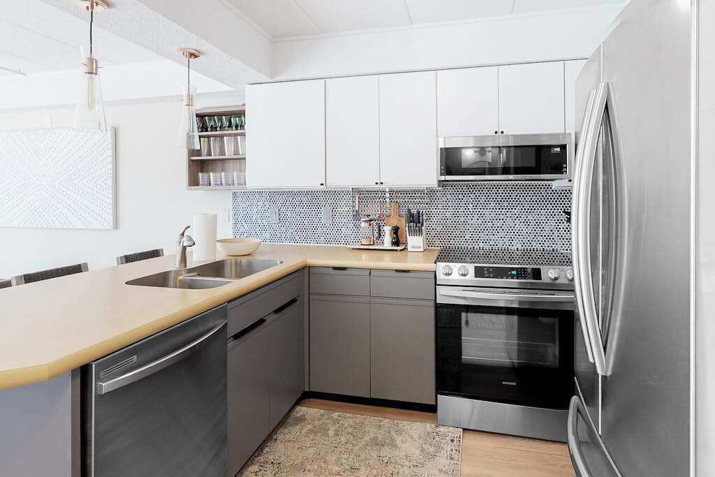 A modern kitchen with stainless steel appliances, a dishwasher, and a microwave.