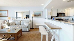 Una sala de estar moderna con un sofá, una mesa de centro y un comedor con un banco.