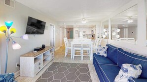Una sala de estar moderna con sofá, mesa de comedor y televisor.