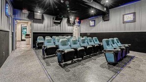 Ein Kino mit Sitzreihen, einem Notausgang und einer Projektionsleinwand.