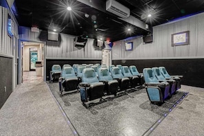 Ein Kino mit Sitzreihen, einem Notausgang und einer Projektionsleinwand.