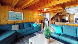 Ein Zimmer mit Holzausstattung, einem Sofa, einem Couchtisch und einem Bild an der Wand.