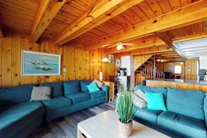 Ein Zimmer mit Holzausstattung, einem Sofa, einem Couchtisch und einem Bild an der Wand.