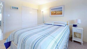 A bedroom with a bed, bedside table, lamp, and a framed picture on the wall. - Sea Place 108 (Ocean City)