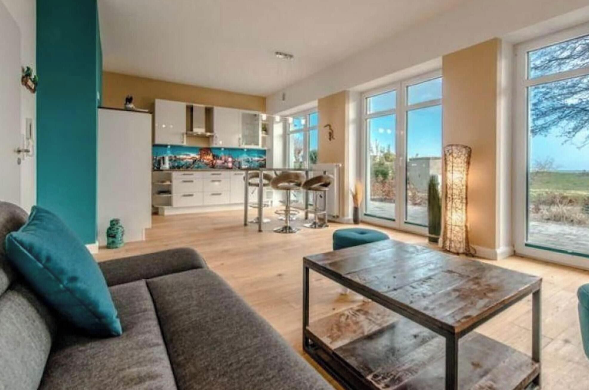 Ein modernes Wohnzimmer mit einer Couch, einem Couchtisch und Blick auf eine Küche und einen Essbereich.