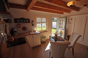 Eine Küche mit Holzausstattung, einem Spülbecken und einem Essbereich mit Tisch und Stuhl.