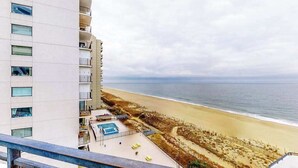 Un immeuble de grande hauteur avec piscine et vue sur la plage.