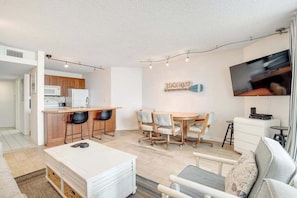 A modern apartment with a kitchen, dining area, and living room. - Newly Updated, Oceanfront Condo with New AC, WiFi, Balcony & Shared Pool (Ocean City)