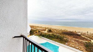 En balkon med udsigt over strand og hav.