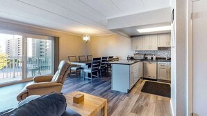 Ein modernes Apartment mit Essbereich, Küche und Balkon.