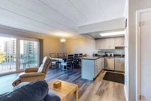 A modern apartment with a dining area, kitchen, and a balcony. - Newly Renovated Condo Steps from the Beach with AC, WiFi & Shared Pool (Ocean City)
