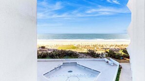 A rooftop pool with a view of the beach and ocean. - Newly Renovated, Oceanfront Condo with Balcony, Great View, AC & Shared Pool (Ocean City)