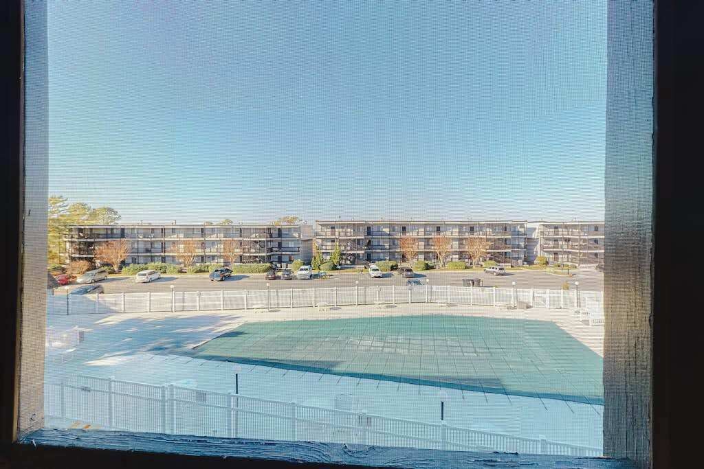En vy över ett parkeringshus med flera våningar, med en sportplan i förgrunden.