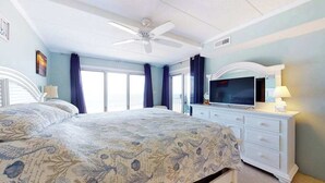 A bedroom with a bed, a TV, a dresser, and a ceiling fan. - Renovated, Oceanfront Condo w/ Gorgeous Ocean Views, Balcony, AC & WiFi (Ocean City)