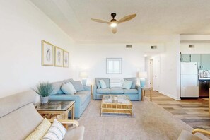 A living room with a sofa, coffee table, and a ceiling fan. - Our Place At The Beach 304C (Ocean City)