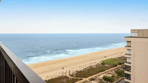 Uitzicht op het strand vanaf een balkon, met een heldere lucht.