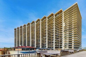 Ein Wolkenkratzer-Hotel mit zahlreichen Balkonen, einem Poolbereich und einer Promenade.