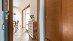 A hallway with a wooden door, a dresser, a plant, and a telephone. - D Ossuna Central Home by Wonderful Italy (Palermo)
