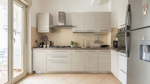 A modern kitchen with light-colored cabinets, a stainless steel refrigerator, and a gas stove. - D Ossuna Central Home by Wonderful Italy (Palermo)