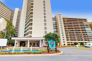 A hotel with a sign for 'Sea Watch' and a parking lot. - Convenient & breezy condo with balcony, pools, tennis, sauna & gym (Ocean City)