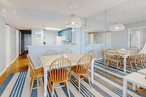 Eine moderne Küche mit einer zentralen Kochinsel, Holzstühlen und einem Streifenmuster-Teppich.