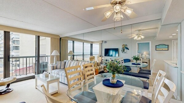 Ein modernes Hotelzimmer mit Balkon, Essbereich, Wohnbereich und Fernseher.