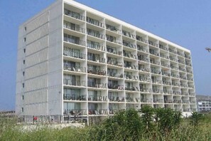 Ein mehrstöckiges Hotel mit Balkonen, einer glatten Fassade und blauem Himmel.