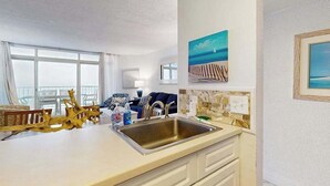 Eine Küche mit großem Fenster, Spüle und Essbereich mit Blick.