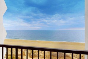 Ein Balkon mit Blick auf Strand und Meer.