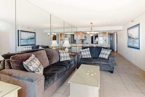A modern living room with two sofas, a coffee table, and a kitchen in the background. - Plaza 1307 (Ocean City)