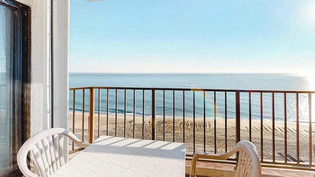 Un balcón con vista a la playa y al océano.