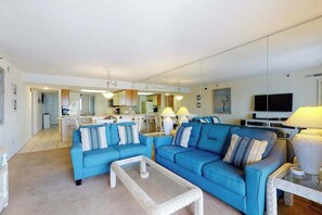 A living room with a blue sofa set, a coffee table, and a TV. - Plaza 1511 (Ocean City)