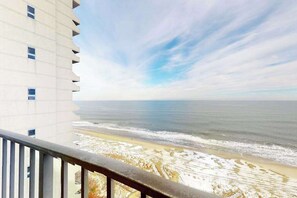A high-rise building with a balcony overlooking a beach with a clear sky. - Plaza 1511 (Ocean City)