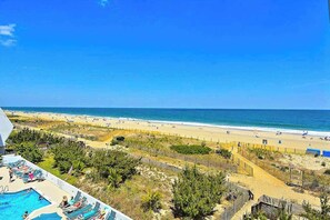 Blick auf einen Strand mit Schwimmbad und Liegestühlen.