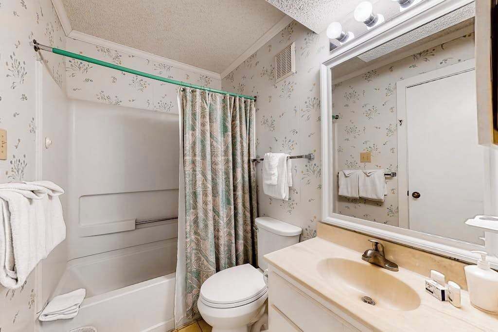 A bathroom with a bathtub, toilet, and sink.