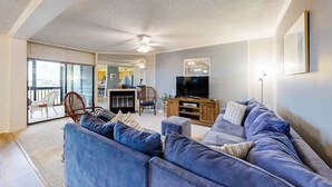 Ein Wohnzimmer mit einer Couch, einem Fernseher und einem Deckenventilator.
