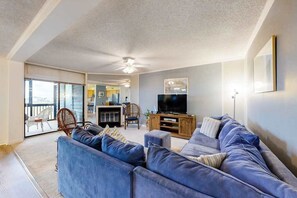 Ein Wohnzimmer mit einer Couch, einem Fernseher und einem Deckenventilator.