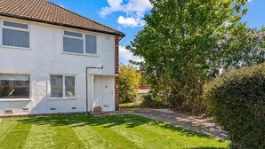 A two-story house with a well-maintained lawn and a large tree in the yard. - Modern 2-Bed Apartment in Reading (Berkshire)