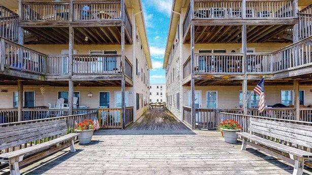 Ein mehrgeschossiges Hotel mit Balkonen, einem zentralen Durchgang und amerikanischen Flaggen.