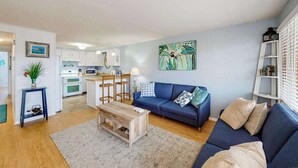 Ein Wohnzimmer mit einer Couch, einem Couchtisch und einem Bild an der Wand.