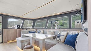 A modern interior with a sofa, table, and large windows.
