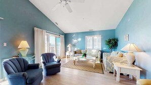 Ein Wohnzimmer mit Deckenventilator, Sofa, Couchtisch und Lampe.