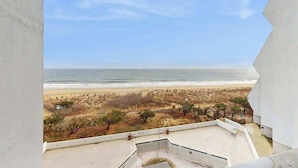 Un balcón con vista a la playa y el océano.