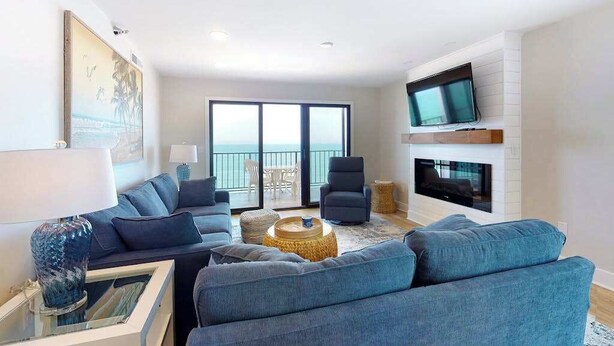 Uma sala de estar moderna com sofá, televisão e lareira.