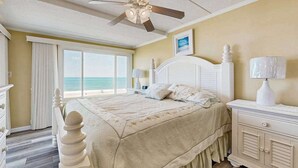 A bedroom with a bed, a nightstand, a ceiling fan, a window with a view of the ocean, and a dresser. - Airy Beachfront Condo w/Great Views, Private Balcony, W/D, Shared Outdoor Pool (Ocean City)