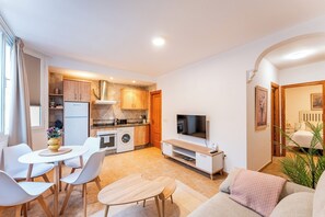 Eine moderne Wohnung mit Essbereich, Küche, Wohnzimmer und Fernseher.